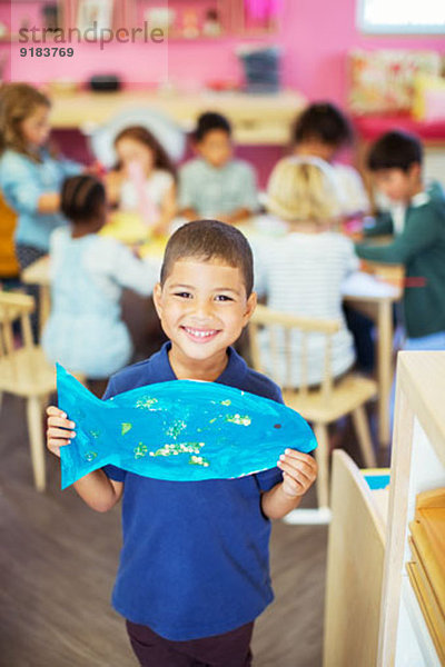 Schüler mit gemalten Fischen im Klassenzimmer