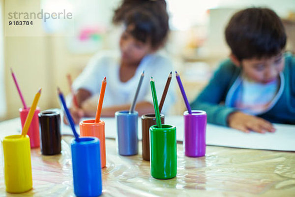 Buntstifte auf dem Schreibtisch im Klassenzimmer