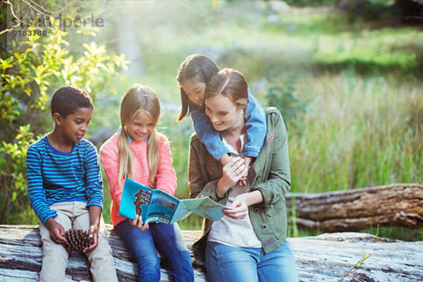 Schüler und Lehrer lesen Karte im Wald