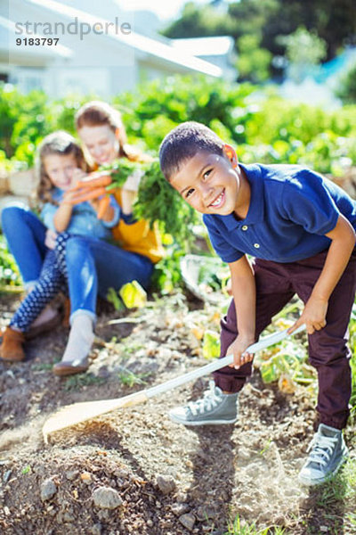 Junge dreht Dreck im Garten um