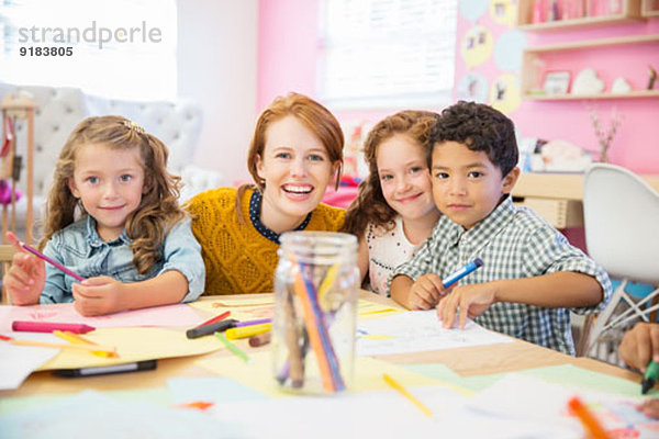 Schüler und Lehrer lächeln im Klassenzimmer