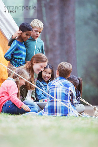 Schüler und Lehrer lesen auf dem Campingplatz