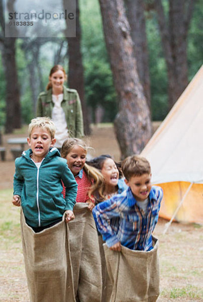 Kinder beim Sackhüpfen auf dem Campingplatz