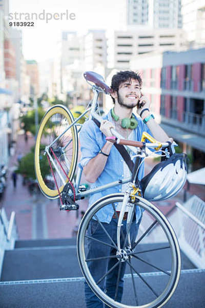 Mann mit Fahrrad auf Stadttreppe