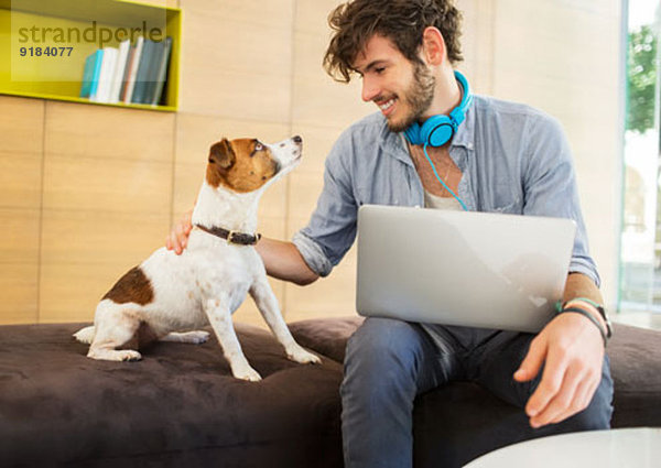 Mann streichelnder Hund im Büro