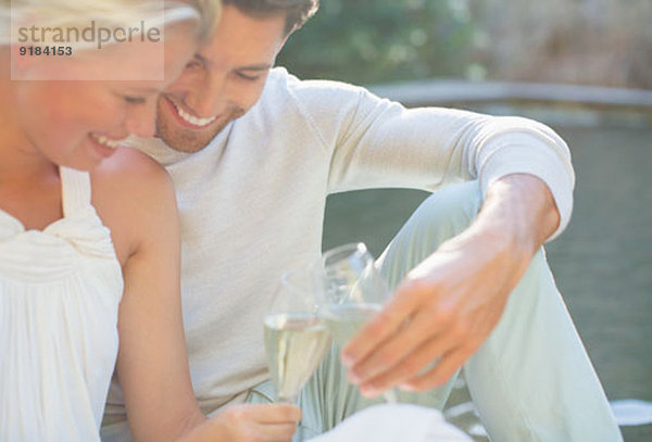 Paare toasten sich gegenseitig mit Champagner im Freien.