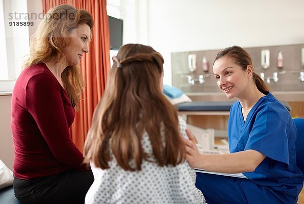 Krankenschwester im Gespräch mit Patientin und Mutter