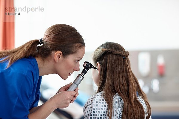 Krankenschwester mit Otoskop am Mädchen