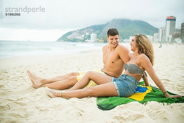 Junges Paar auf brasilianischer Flagge  Ipanema Beach  Rio de Janeiro  Brasilien