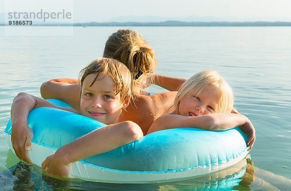 Mutter mit Tochter und Sohn im aufblasbaren Ring  Starnberger See  Bayern  Deutschland