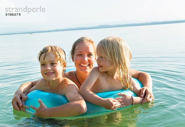 Mutter mit Tochter und Sohn im aufblasbaren Ring  Starnberger See  Bayern  Deutschland