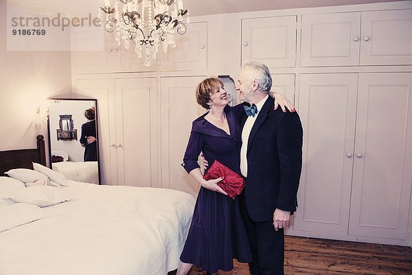 Paar im Schlafzimmer  reife Frau mit Arm um den älteren Mann