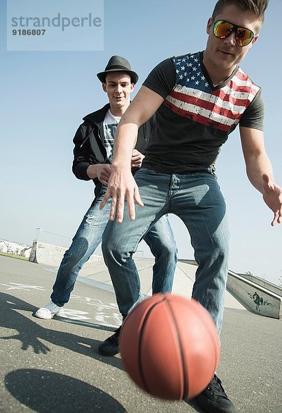 Junge Männer beim Basketball im Skatepark