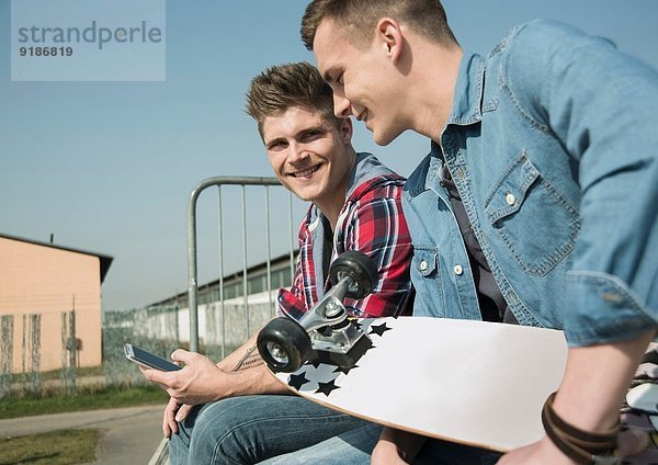 Junge Männer im Skatepark mit Smartphone