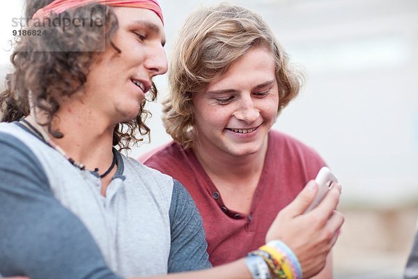 Zwei junge männliche erwachsene Freunde auf dem Smartphone