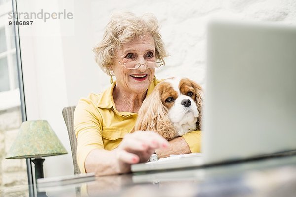 Seniorin mit Hund  mit Laptop