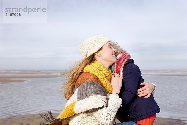 Mittlere erwachsene Frau umarmt Tochter am Strand  Bloemendaal aan Zee  Niederlande