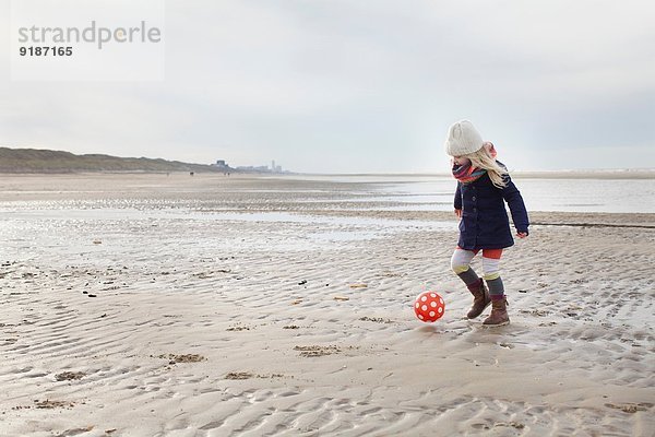 Dreijähriges Mädchen spielt Fußball am Strand  Bloemendaal aan Zee  Niederlande
