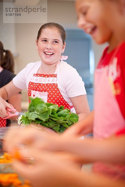 Teenagermädchen bereiten Gemüse in der Küche zu