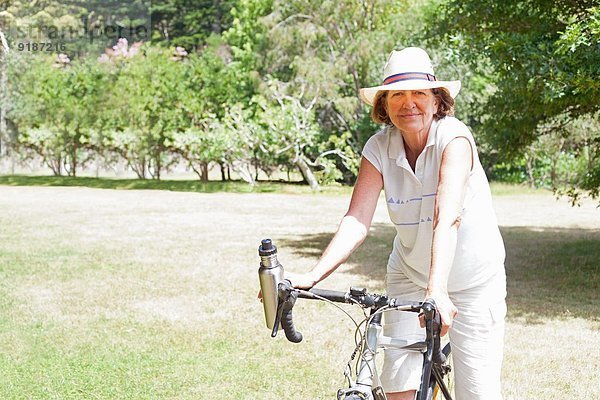 Porträt einer älteren Radfahrerin im Park