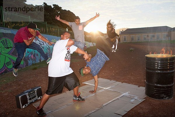 Gruppe von fünf Männern Breakdance im Park in der Abenddämmerung