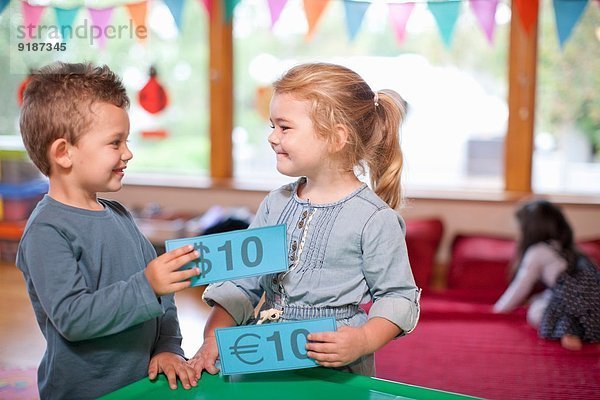 Junge und Mädchen zählen Euro-Währung im Kindergarten