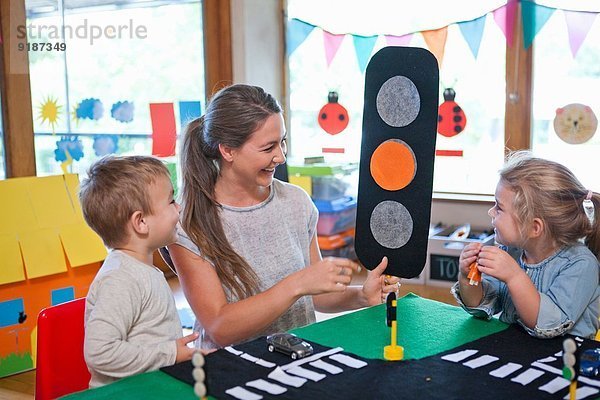 Lehrer und Schüler lernen Straßenkreuzung im Kindergarten