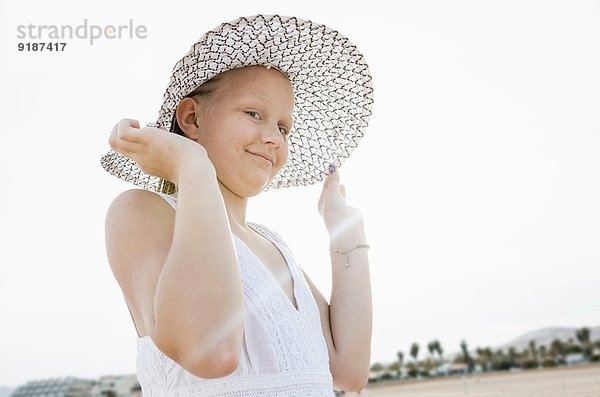 Porträt eines Mädchens mit Sonnenhut am Strand