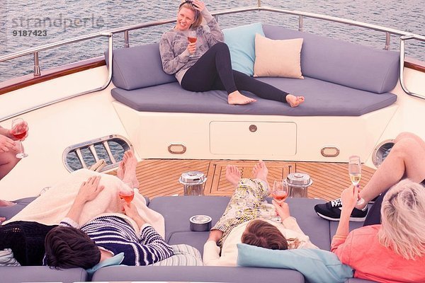 Gruppe erwachsener Freunde bei einem erholsamen Drink an Bord der Yacht