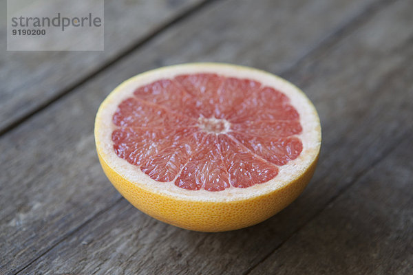 Nahaufnahme von rosa Grapefruit auf Holztisch