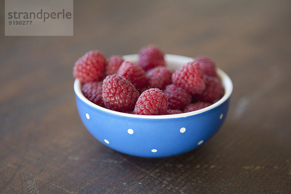 Nahaufnahme von Himbeeren in der Schale auf dem Tisch