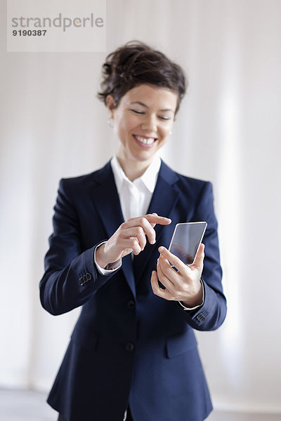 Attraktive Geschäftsfrau mit virtuellem Smartphone