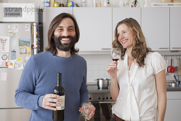 Glückliches Paar genießt Rotwein in der Küche