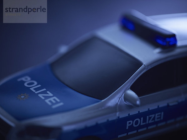 Spielzeug-Polizeiwagen über blauem Hintergrund