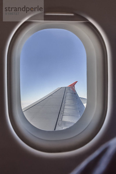 Ansicht des Flugzeugflügels durch das Fenster