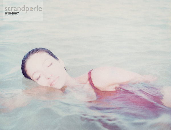 Frau schwimmt im ruhigen Wasser