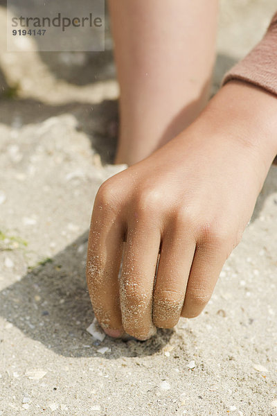 Kind spielt im Sand am Strand  abgeschnitten
