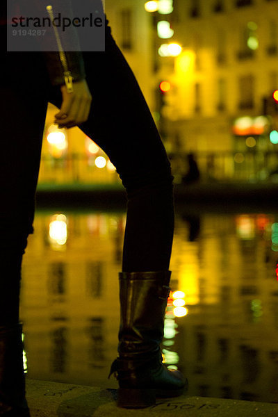 Person  die auf der Uferpromenade steht.