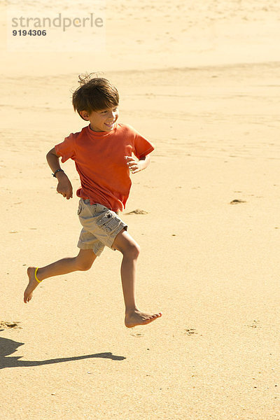 Junge läuft am Strand