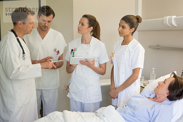 Medizinisches Team betreut Patientin auf dem Krankenhausbett