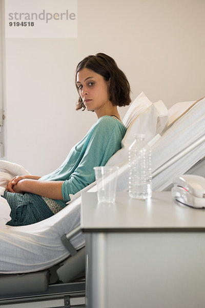 Weibliche depressive Patientin  die sich auf dem Bett in einer Krankenstation niederlegt