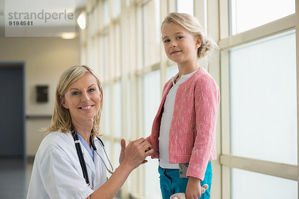Porträt einer Krankenschwester lächelnd mit einem Mädchen