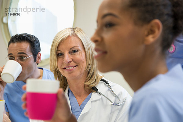 Ärzte und Krankenschwester bei einer Kaffeepause in der Krankenhauskantine