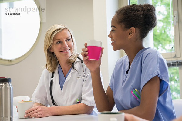 Ärztin und Krankenschwester bei einer Tasse Kaffee in der Krankenhauskantine