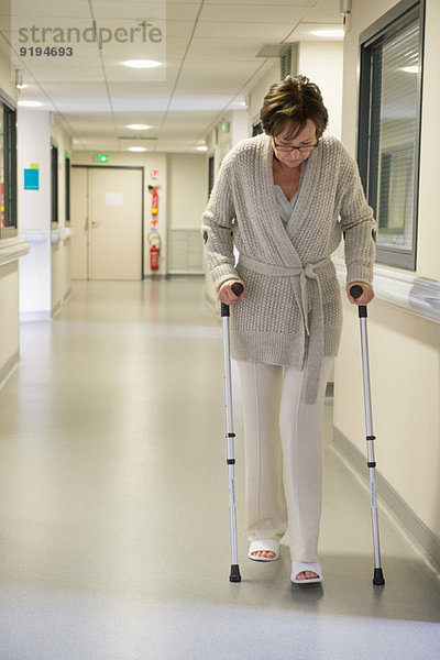 Patientin beim Gehen mit Hilfe von Krücken