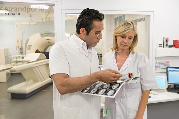 Ärzte untersuchen MRT-Bericht im medizinischen Untersuchungsraum