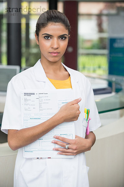 Porträt einer Ärztin mit Arztbriefen im Krankenhaus