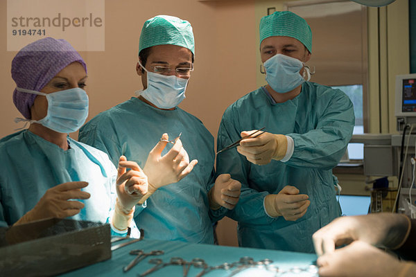 Chirurgen  die einen Patienten in einem Operationssaal operieren