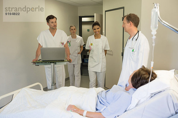 Medizinisches Team betreut Patientin auf dem Krankenhausbett
