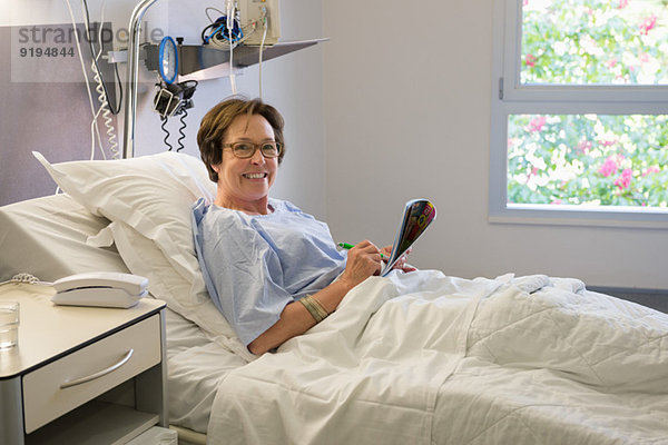 Frau lächelt auf Krankenhausbett